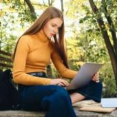 Casual female student on laptop creating good habits