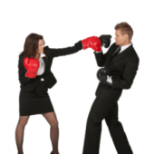 Man and woman in business suits with boxing gloves on