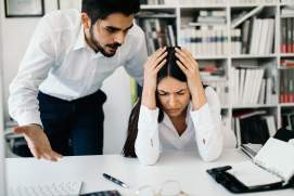 businessman yelling at female colleague in office
